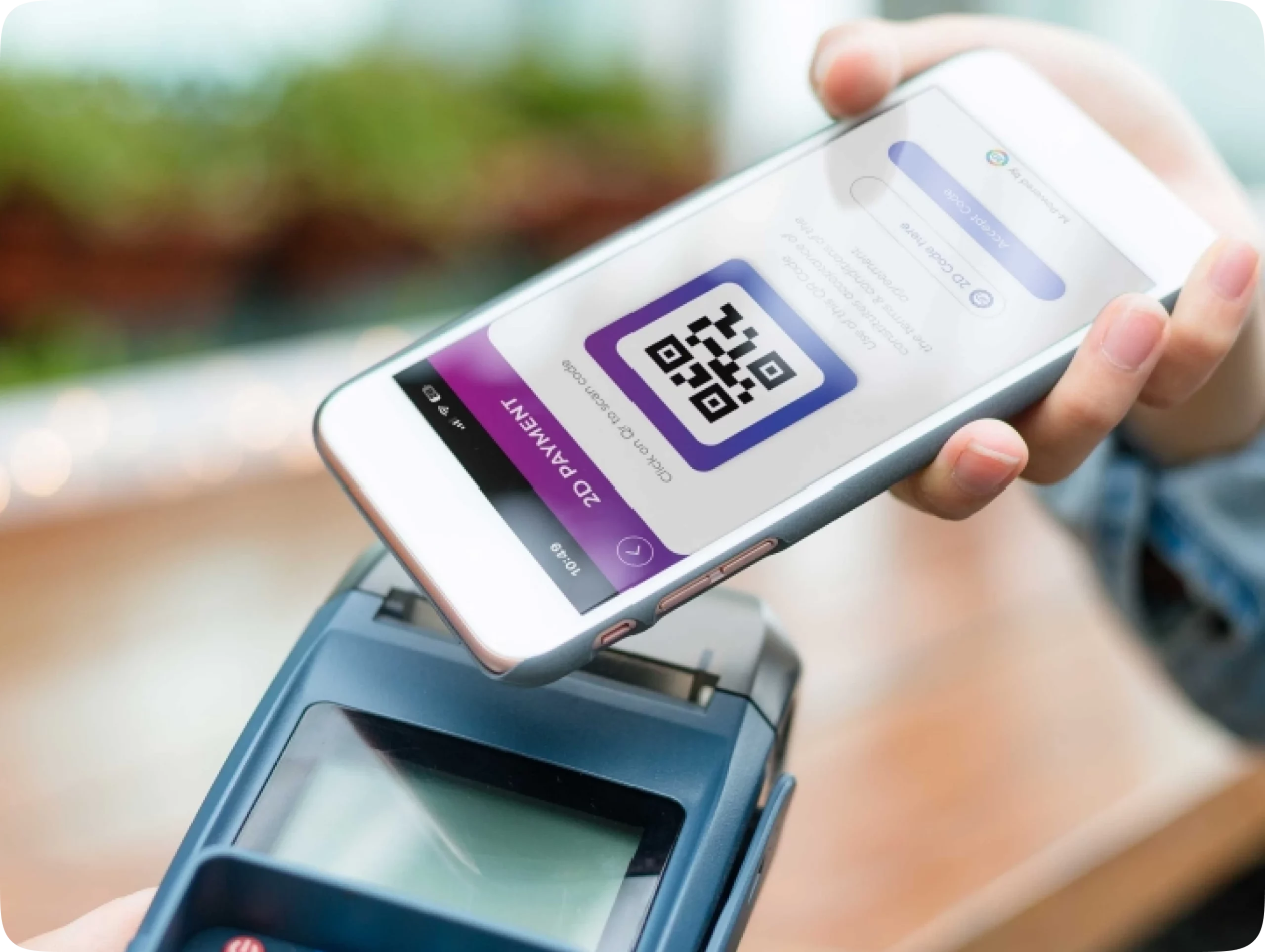 Hand holding a smartphone scanning a QR code for PointsKash mobile payment